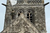 An effigy of John Steele hanging on the church of Sainte Mère Eglise – Normandy and the D-Day Landings Tour
